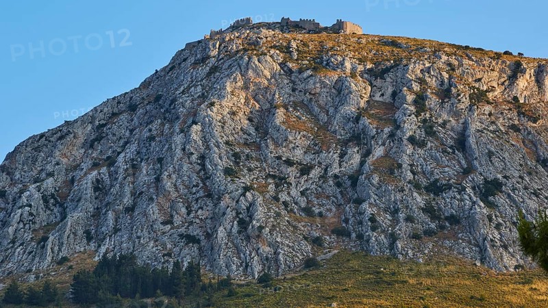 The golden hour illuminates a mountain with an ancient castle at the top, Archaic Castle, Akrokorinthos, Corinth, Peloponnese, Greece, Europe