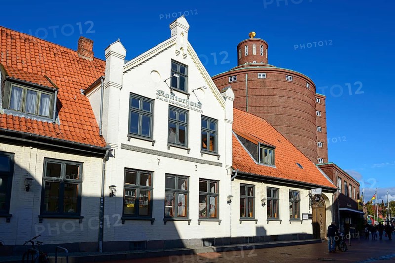 A white traditional building with a tiled roof in the foreground in front of an unusual round tower under a blue sky, Kontorhaus, Kontorgebäude, Kulturdenkmal, and historic granary, Eckernförde, Schleswig-Holstein, Germany, Europe