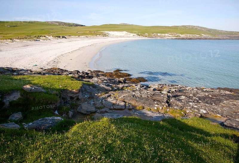 Rocky headland and sandy beach at Bagh a Deas, South Bay, Vatersay island, Barra, Outer Hebrides, Scotland, UK