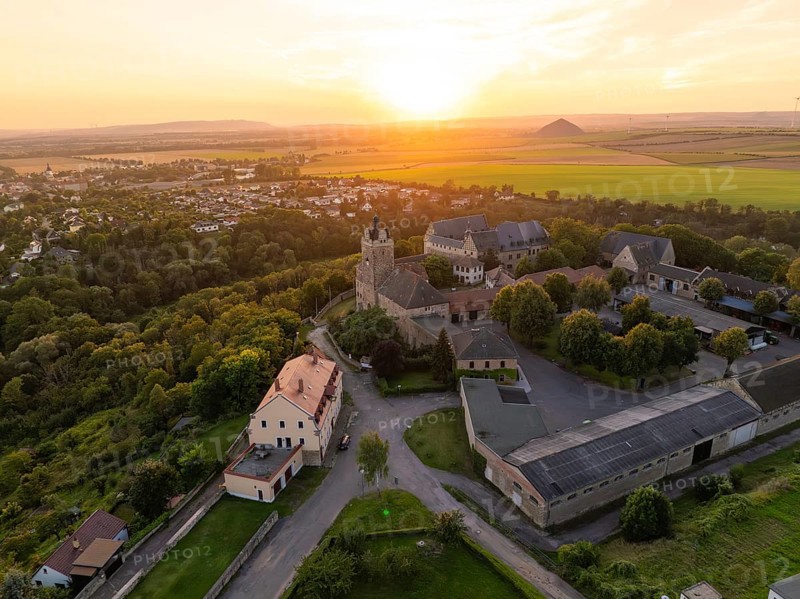 Aerial view of a castle in the warm light of sunset, surrounded by houses and fields, Allstedt, Harz, Germany, Europe