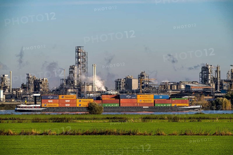 Cargo ship on the Rhine near Emmerich, Kao Chemicals backdrop, specialising in surfactants, KLK, Left Rhine pastures, Lower Rhine, North Rhine-Westphalia, Germany, Europe