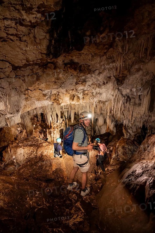 Young man with helmet and headlamp, tourist between stalactites and stalagmites in a stalactite cave, Terciopelo Cave, Barra Honda National Park, Costa Rica, Central America