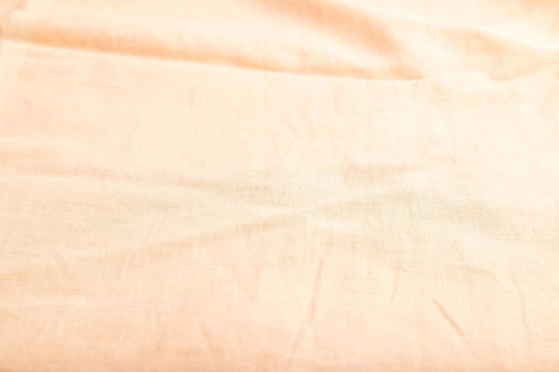 Fragment of smooth orange linen tissue. Side view, natural textile background and texture