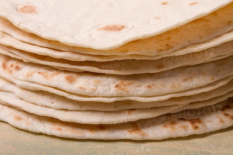 A stack of Mexican tortillas, on a gray table, top view, close-up, no people