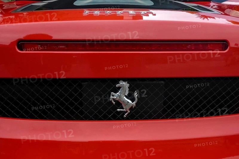 Close-up detail of red rear end of sports car Supercar Ferrari Spyder with logo trademark of luxury car manufacturer Jumping horse Cavallino Rampante, international