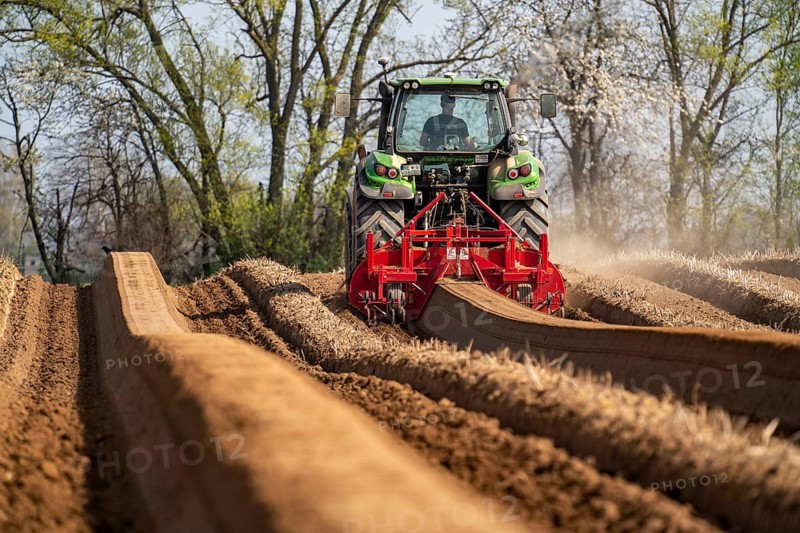 A farmer builds asparagus ridges on a field with the help of an asparagus tiller, in which the asparagus then grows, Dormagen, North Rhine-Westphalia, Germany, Europe