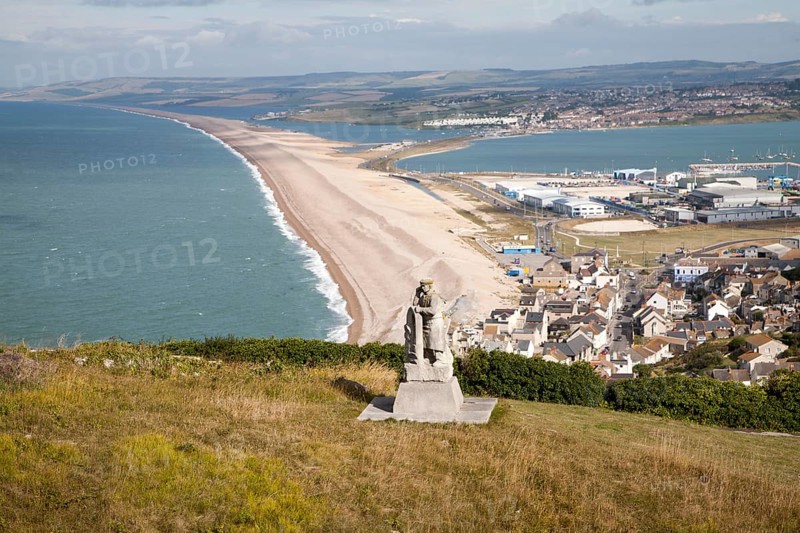 Chesil beach tombolo, with quarrying monument in the foreground Chiswell, Isle of Portland, Dorset, England, United Kingdom, Europe