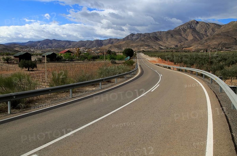 Modern road leading to mountains of Sierra de Baza range near village of Uleila del Campo, Almeria, Spain, Europe