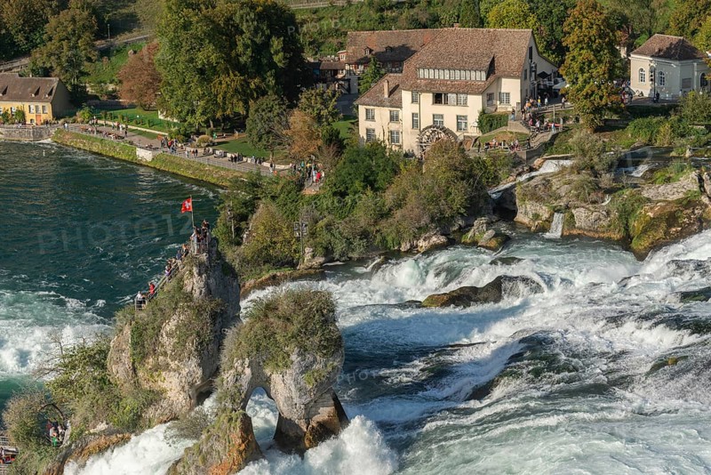 Rhine Falls seen from Laufen Castle, rocky island, Swiss flag, rapids, watermill, Canton Zurich, on Neuhausen, Switzerland, Europe