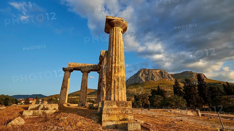 Archaic Temple of Apollo, Doric columns, Golden light falls on the ancient columns with picturesque mountains in the background, Archaeological site, Archea Korinthos, Corinth, Peloponnese, Greece, Europe