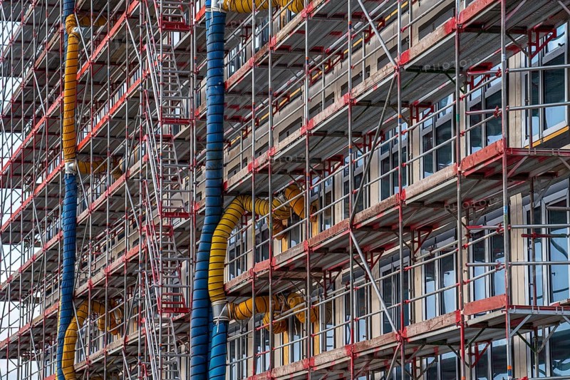 Large construction site, scaffolded shell of an office building complex, air hoses for building ventilation, heating, O-Werk Campus in Bochum, North Rhine-Westphalia, Germany, Europe