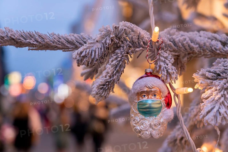 Symbolic picture Christmas in the Corona crisis, Father Christmas figure, Christmas tree decoration, with mouth-nose mask, everyday mask, in a pedestrian zone, shopping street