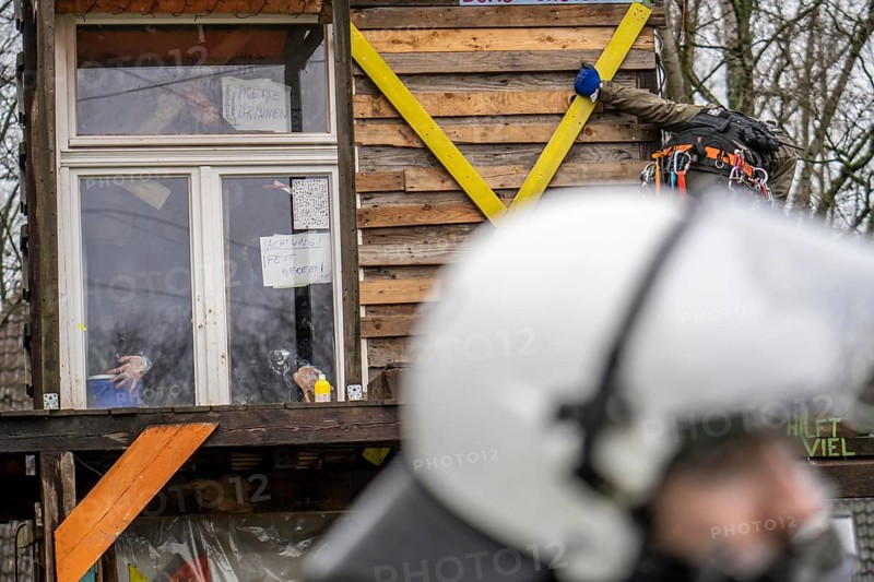 2nd day of the clearing of the hamlet Lützerath, by the police, of tree houses and huts, activist has taped herself to the glass pane of a window, from the inside, at the opencast lignite mine Garzweiler 2, Erkelenz, North Rhine-Westphalia, Germany, Europe