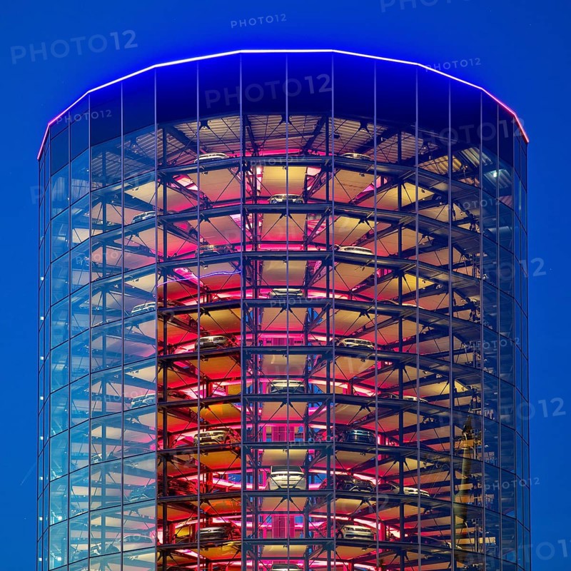An illuminated car tower with new cars for delivery in the evening, Autostadt, Volkswagen AG, Wolfsburg, Lower Saxony, Germany, Europe