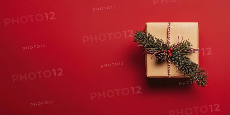 Banner with small Christmas gift box wrapped in graft paper on red background with copy space. Generative Ai, AI generated