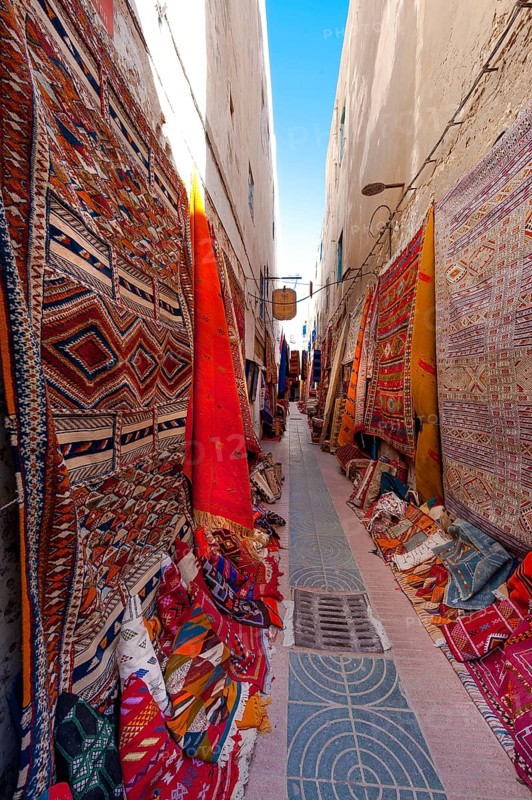 Alley with carpet dealers, carpet, trade, market, dealer, bazaar, offer, colourful, colourful, craft, hand-woven, Islam, souk, medina, product presentation, display, trade, economy, tourism, Sovenian, travel, African, Arabic, Essaouira, Morocco, Africa