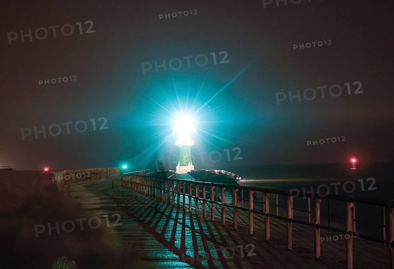 A lighthouse on the pier shows ships the way to Rostock harbour, Warnemünde, 09.02.2023