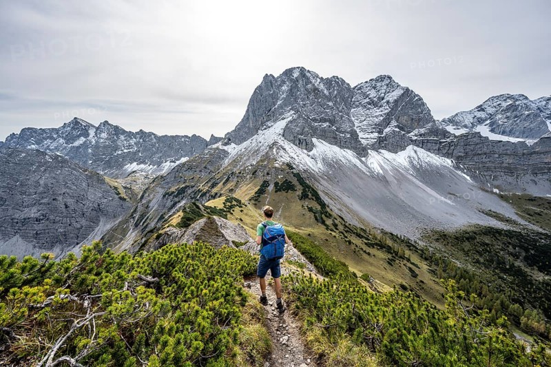 Mountaineers on a hiking trail on the ridge of Hahnkampl, mountain panorama with rocky steep peaks, view of summit Lamsenspitze, in autumn, Karwendel Mountains, Alpenpark Karwendel, Tyrol, Austria, Europe