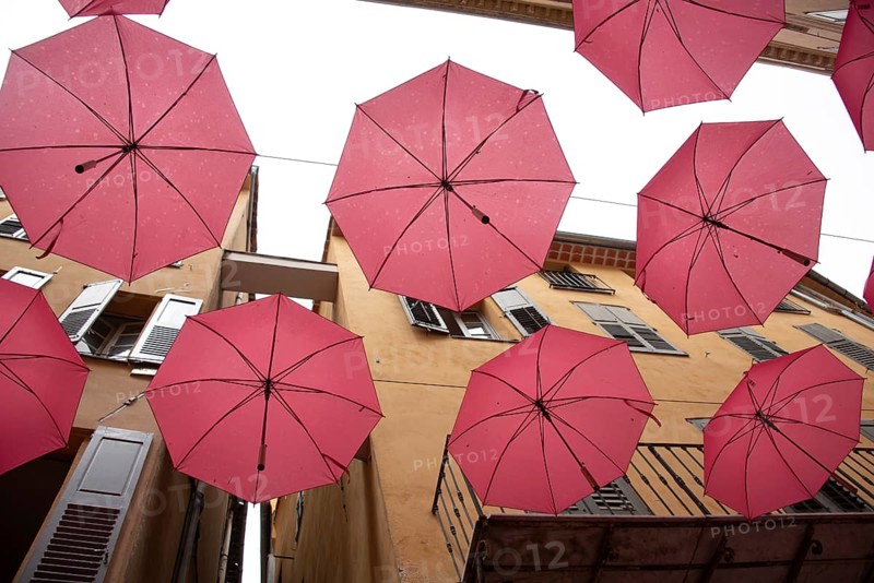 In the perfume town of Grasse, red umbrellas hang between the houses, Grasse, Provence-Alpes-Côte d'Azur, France, Europe