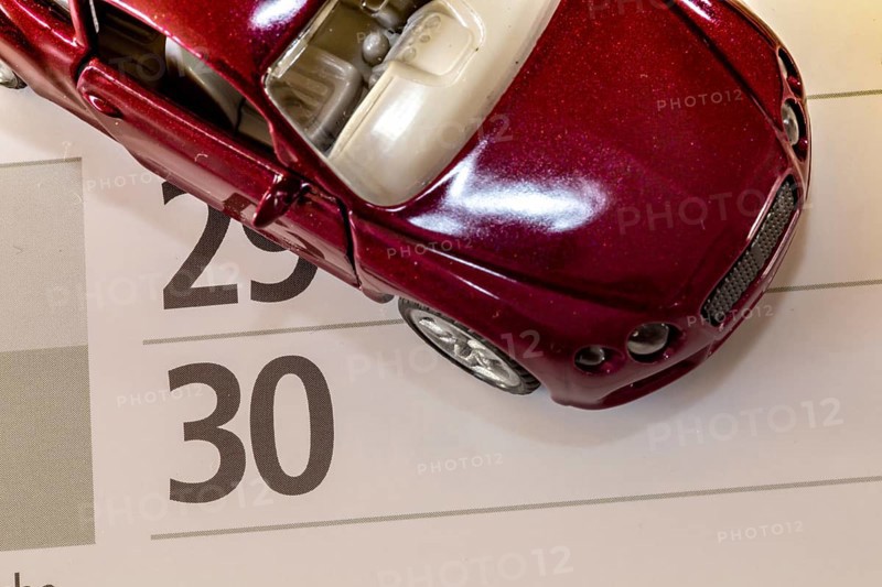 Deadline for changing car insurance (symbolic image with model car and calendar)