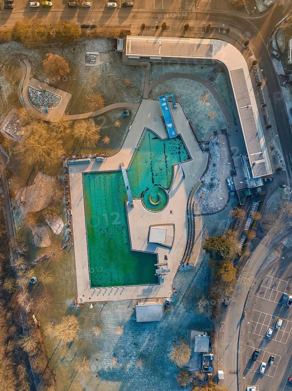 Drone image of an outdoor pool during twilight hours in an urban environment with frozen water ENCW outdoor pool Calw, Stammheim, Black Forest, Germany, Europe