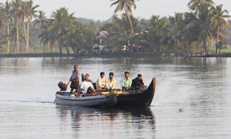 Indian men travelling on a motorboat, canal system of the backwaters, Kerala, India, Asia