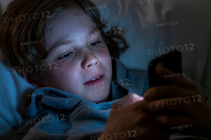 A boy plays computer games on a mobile phone, smartphone