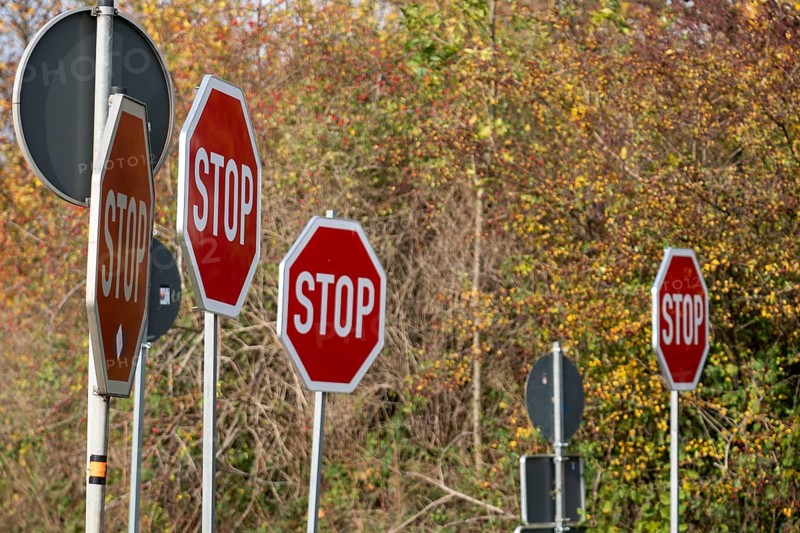Several STOP signs next to each other, traffic signs