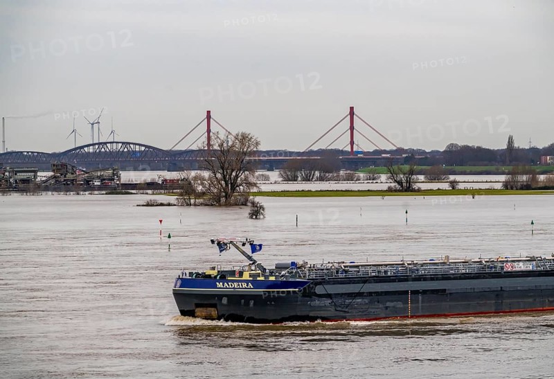 Flood on the Rhine near Duisburg, view from Ruhrort to the north, over the Rhine meadows of Duisburg-Homberg, to the motorway bridge of the A42, between Duisburg-Baerl and Duisburg-Beeckerwerht, cargo ship, washed by the flood, North Rhine-Westphalia, Germany, Europe