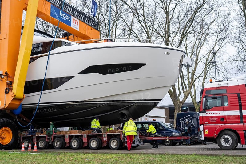 Craning the €6.3 million Sunseeker 88Y motor yacht, weighing 82 tonnes, in preparation for the world's largest water sports trade fair, Boot in Düsseldorf, luxury yachts are driven across the Rhine to the trade fair and brought ashore with the help of the Big Willi ship crane and transported to the exhibition halls on a low-loader, North Rhine-Westphalia, Germany, Europe