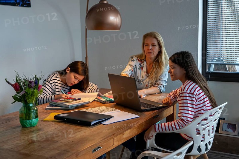 Homeschooling, during the lockdown in January 2021, mother helps her two daughters, at home, learning, with textbooks and computers, school closures, distance learning, effects of the corona crisis in Germany