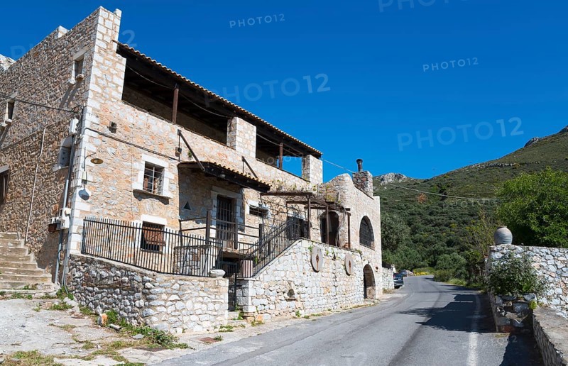 A traditional stone house on a village street with Mediterranean flair and blue sky in the background, Vathia, Ithylo, Anatoliki Mani, Mani, Laconia, Laconia, Peloponnese, Greece, Europe
