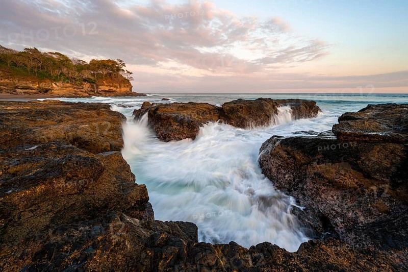 Waves washing over rocks by the sea, long exposure, coastal landscape at sunset, Playa Cocalito, Pacific coast, Nicoya Peninsula, Puntarenas province, Costa Rica, Central America