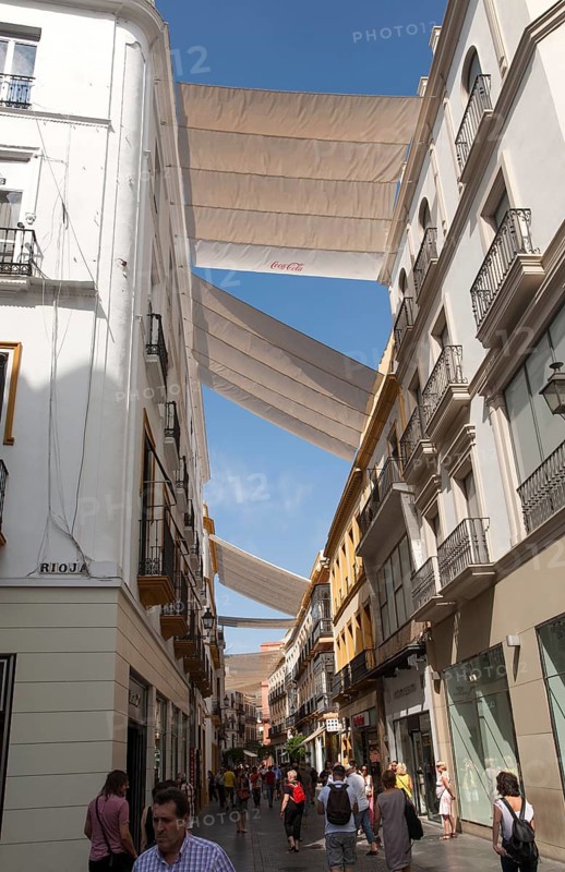 Fabric spread over buildings to provide shade in busy shopping street Mendez Nunez in central Seville, Spain, Europe