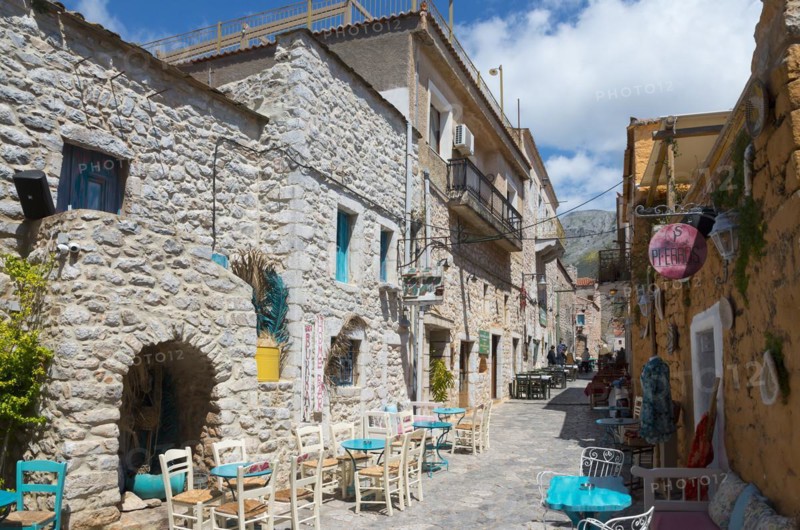 Cosy alley with stone houses and a alleyway café in a small Mediterranean town on a sunny day, Old Town, Areopoli, Areopolis, Tsimova, Itylo, Anatoliki Mani, Mani, Laconia, Peloponnese, Greece, Europe
