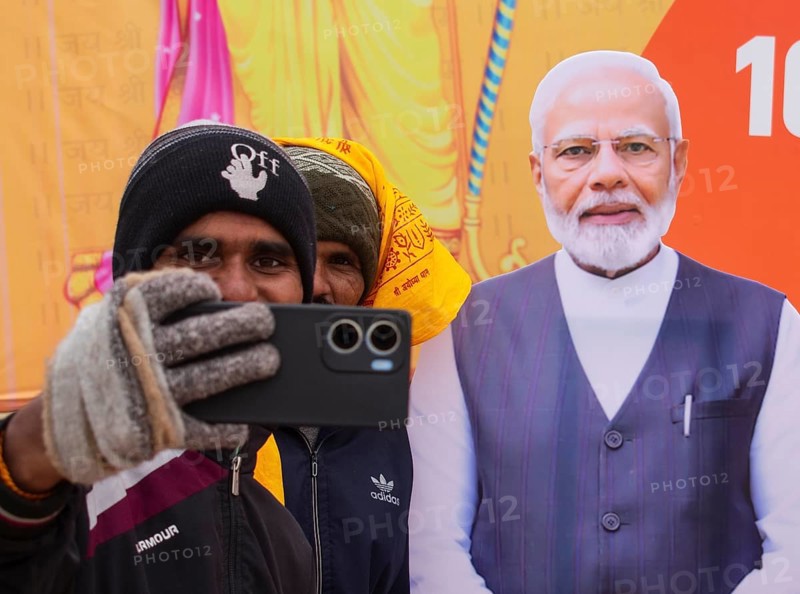 People takes selfie with a cutout poster of Indian Prime Minister Naredra Modi, on the eve consecration ceremony of the Ram temple, in Ayodhya, Uttar Pradesh, India on 22 January 2024