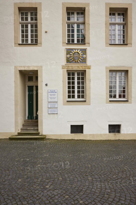 Facade of a historic building with white windows, door and a colourful family coat of arms in the old town of Warendorf, Warendorf district, North Rhine-Westphalia, Germany, Europe