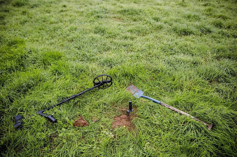 Symbolic photo on the subject of treasure hunting. A metal detector and a spade lie in a meadow. Metal detecting is a hobby that is becoming increasingly popular in Germany. Dresden, 01.10.2022