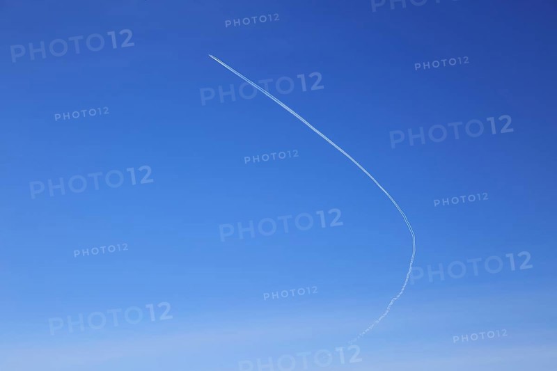 Contrail of airplane outlined in clear blue sky over Suffolk, England, UK