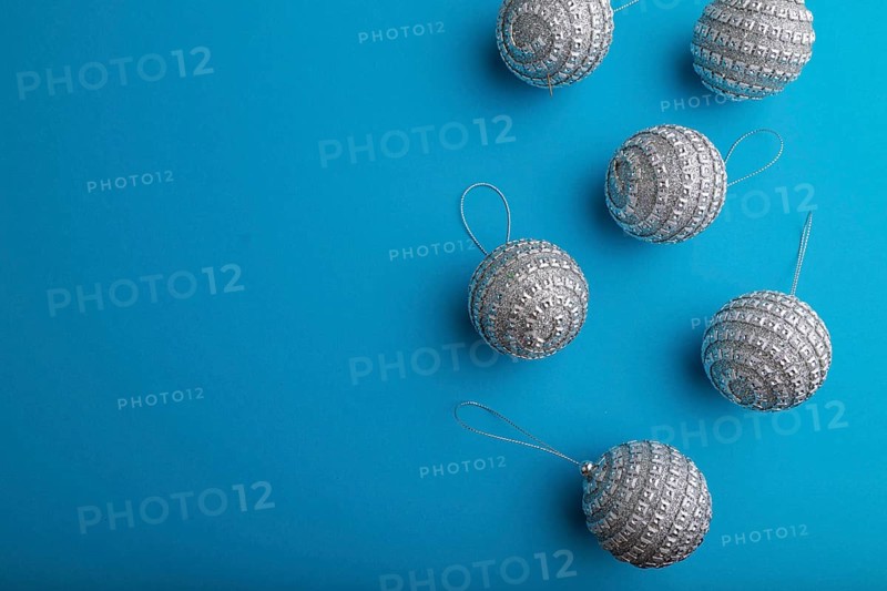 Christmas or New Year composition. Decorations, silver balls, on a blue paper background. Top view, copy space, flat lay
