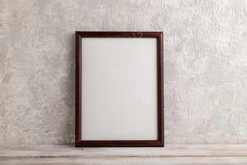 Brown wooden frame mockup on gray concrete background. Blank, vertical orientation, still life, copy space