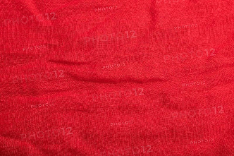 Fragment of smooth red linen tissue. Top view, flat lay, natural textile background and texture