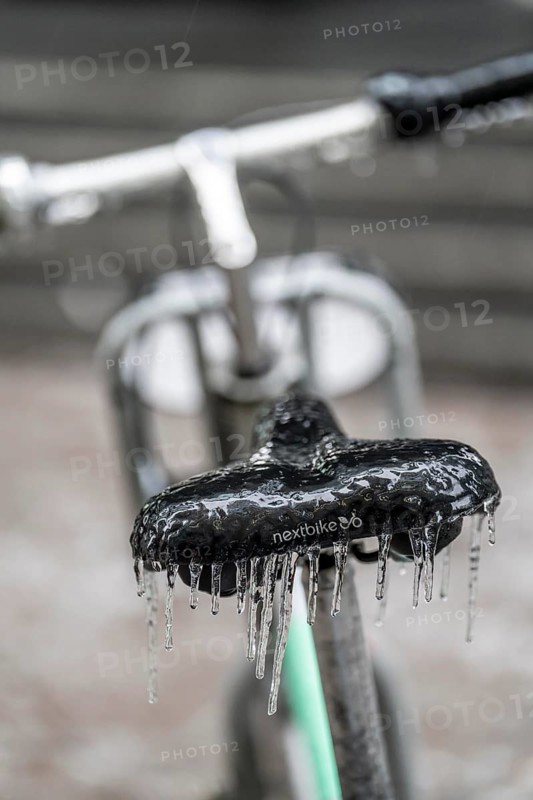 Freezing rain, icy saddle of a rental bike, after freezing rain, in the city centre of Frankfurt, Hesse, Germany, Europe