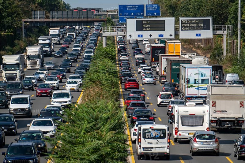 Traffic jam on the A3 motorway, over 8 lanes, in both directions, in front of the Leverkusen motorway junction, Friday afternoon high traffic volume, roadworks, gantry signs with journey times, delays due to the traffic jam, Leverkusen, North Rhine-Westphalia, Germany, Europe