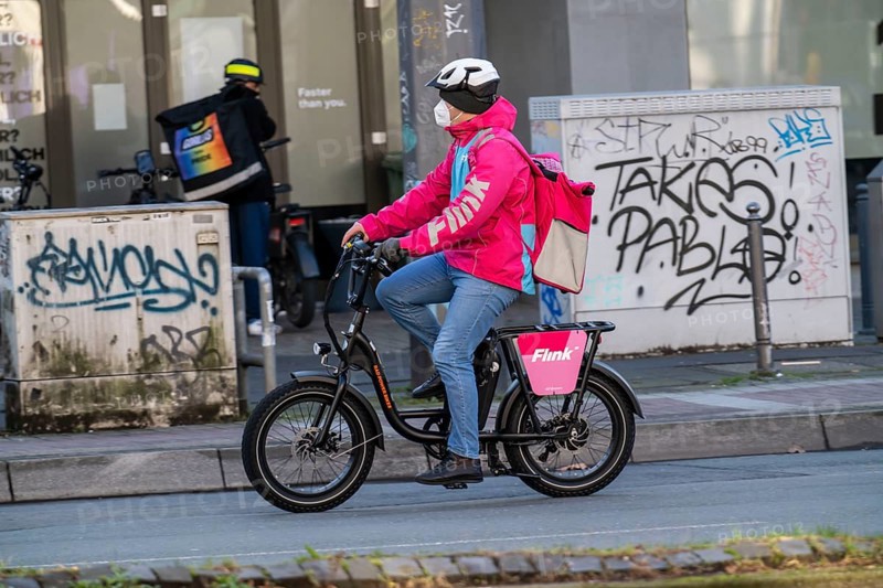 Bicycle courier of the fast delivery service Flink, delivers groceries, currently in over 40 German cities, within 10 minutes, orders via an app, works together with the REWE Group, in the background competitor Gorillas, Bochum, North Rhine-Westphalia, Germany, Europe