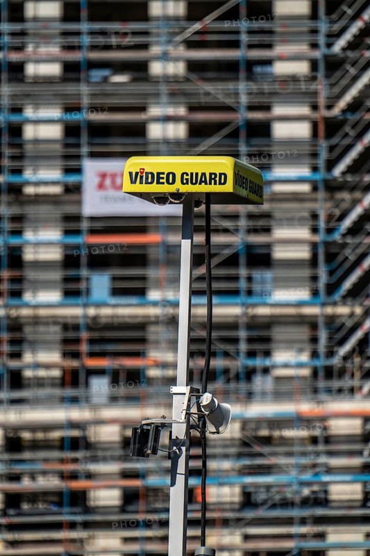 Construction site, at the Cologne Trade Fair Centre, new construction of a high-rise office building, construction cranes, facade of the shell, scaffolding, Video Guard video surveillance of the construction site, North Rhine-Westphalia, Germany, Europe