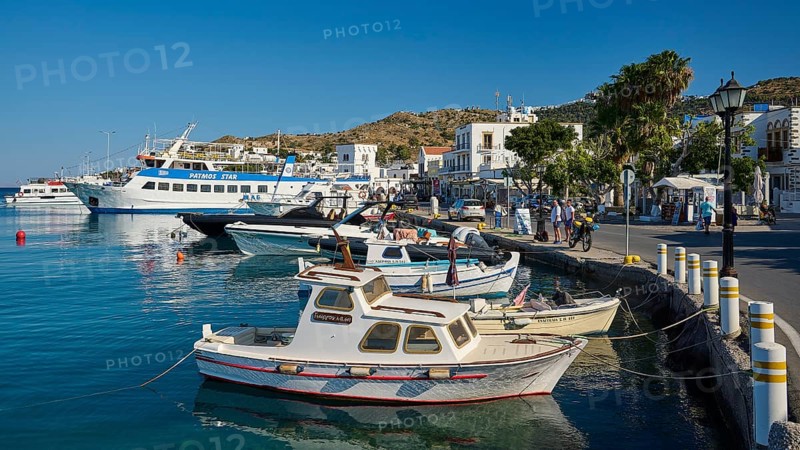 Lively harbour with many boats and white buildings surrounded by blue sea and sky, Skala, Patmos, Dodecanese, Greek Islands, Greece, Europe