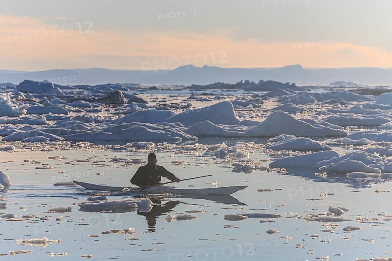 Inuit paddling a kayak between icebergs, man, sunny, summer, Ilulissat, Ilulissat Icefjord, Disko Bay, West Greenland, Greenland, North America