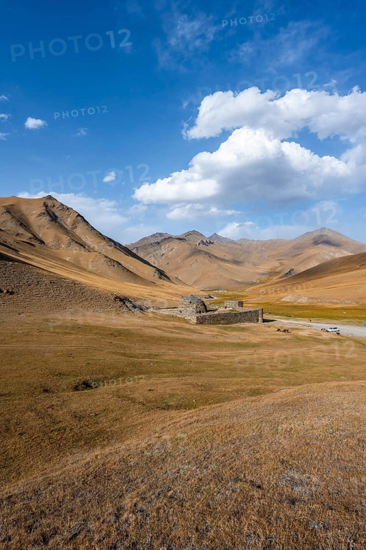 Historic caravanserai Tash Rabat from the 15th century, in the evening light with golden hills, Naryn region, Kyrgyzstan, Asia