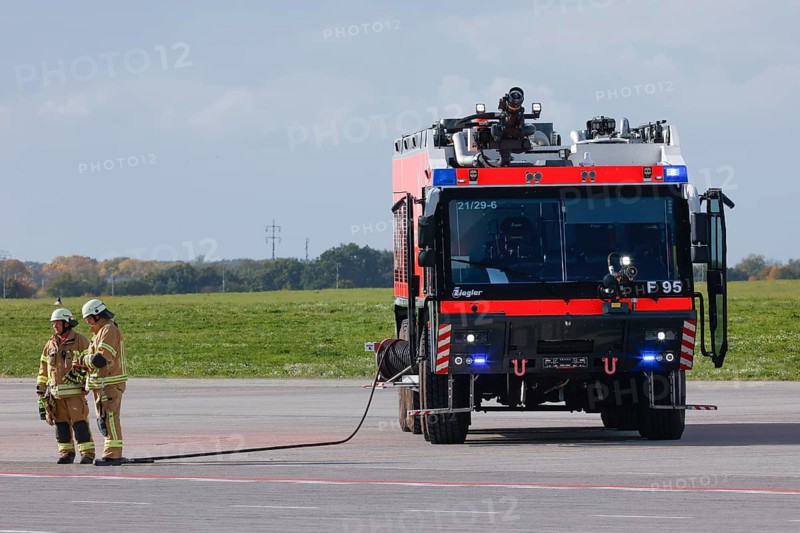Firefighters from the airport fire brigade stand next to a Ziegler F95 fire engine at BER Airport during an EASA emergency exercise. Emergency services rehearsed an emergency in the aviation security area. The airport company rehearsed for an emergency together with the federal police and fire brigade as part of an emergency exercise, Schönefeld, 11 October 2022